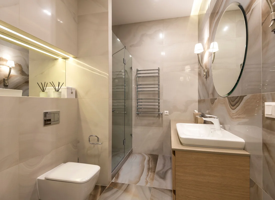 Modern bathroom with tiled walls, fitted vanity and glass shower enclosure