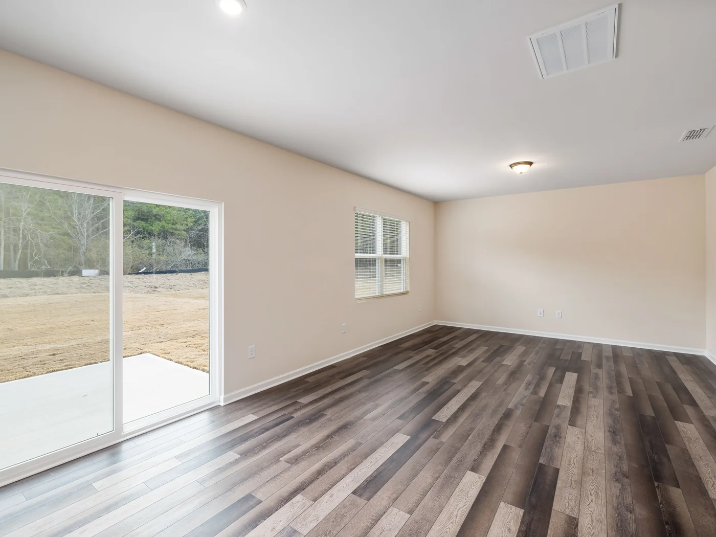 Bright interior room with finished wood flooring and clean walls