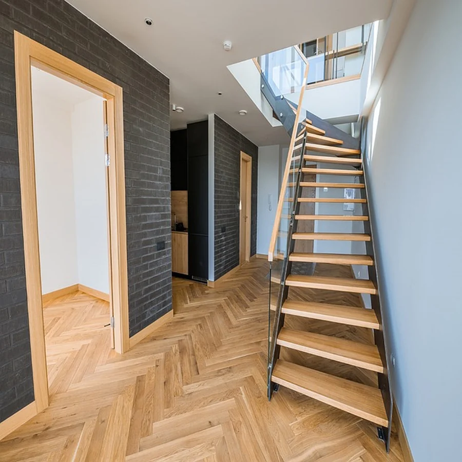 Open staircase with wood treads, glass balustrade and herringbone floor